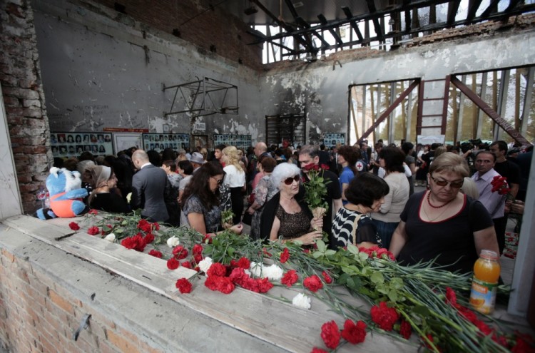 People mourn inside School Number One during a ceremony commemorating the victims of the 2004 hostage crisis in the southern Russian town of Beslan